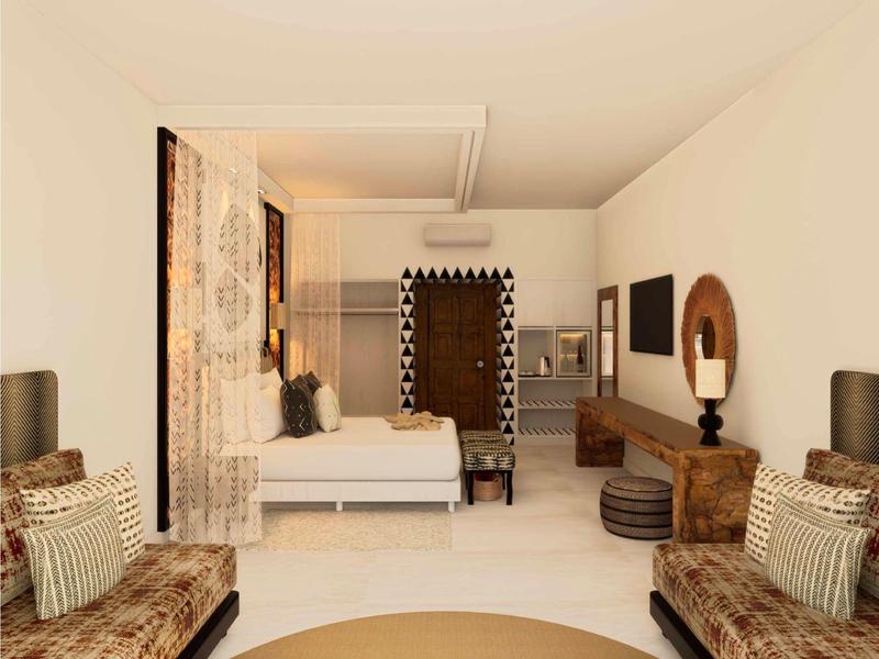 Hell eingerichtetes Hotelzimmer mit Doppelbett, Sofas und dekorativen Teppichen.