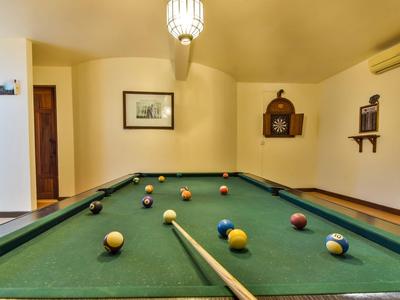 Een pooltafel met gekleurde ballen in een kamer met warm licht en minimale decoratie.