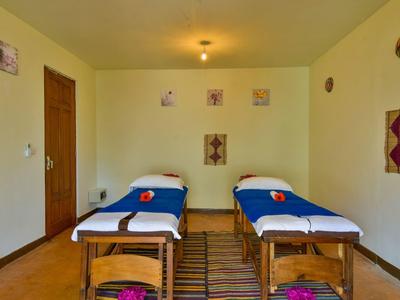 Ein einfach eingerichteter Raum mit zwei Massageliegen und Wanddekorationen.