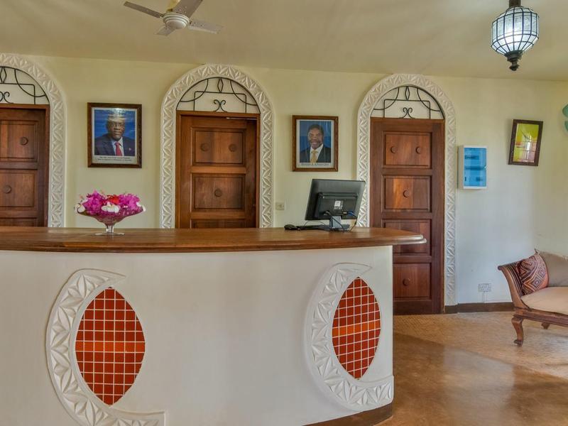 Helle Hotellobby mit rundem Empfangstresen und klassischer Holztür