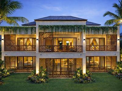 Casa vacanze moderna su due piani con balcone e palme, illuminata al crepuscolo.