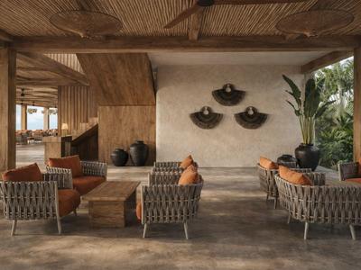 Elegante area lounge con poltrone grigie, soffitto in legno e piante in un hotel.