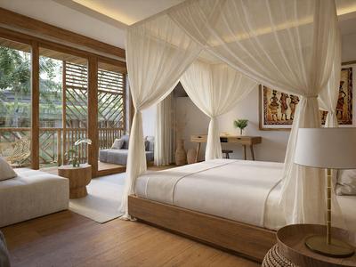 Elegante camera da letto con letto a baldacchino, pavimento in legno e ampie finestre con vista sul giardino.