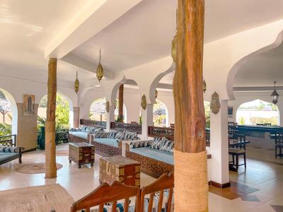 Helle Lounge mit gepolsterten Sitzbänken, Holzbalken und dekorativen Laternen.