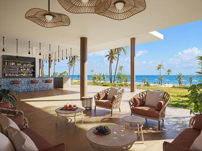 Offener Barbereich mit Stühlen und Tischen, Blick auf Strand und Meer bei Sonnenschein.