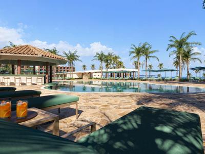 Resort-Poolbereich mit Liegestühlen, Getränken und Palmen unter blauem Himmel.