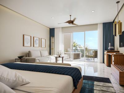 Modern eingerichtetes Hotelzimmer mit Doppelbett, Sofa und Balkon mit Blick aufs Meer.