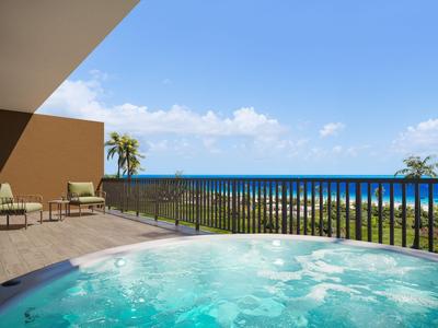 Balkon mit Whirlpool und Blick auf den Ozean bei klarem Himmel
