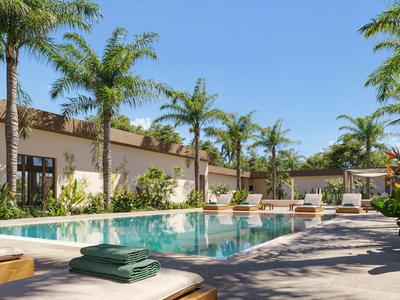 Moderner Außenpoolbereich mit Palmen und Liegestühlen in einem sonnigen Hotel.