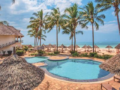 Pool area with sun umbrellas and palm trees on the beach at a tropical resort.