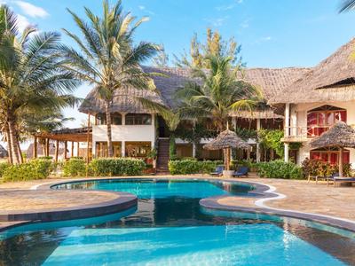 Hotel con piscina, palme e edificio su più piani sotto un cielo limpido.
