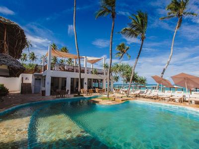 Hotelpool mit Liegestühlen, Palmen und blauem Himmel in tropischer Umgebung
