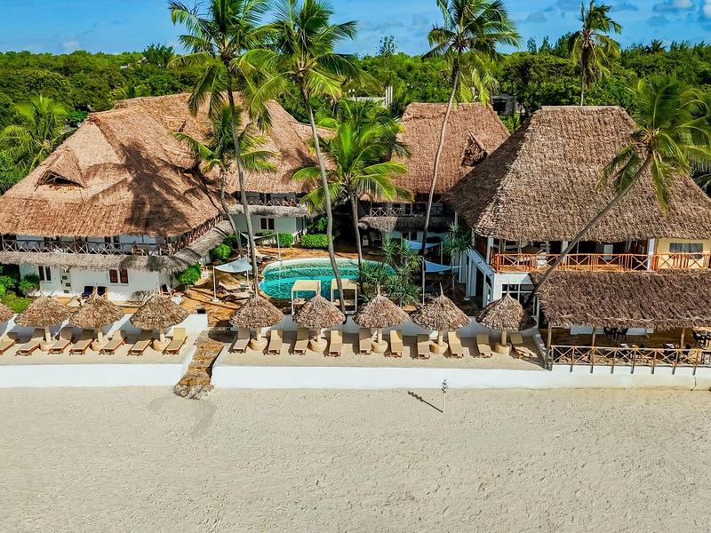 Luxuriöse Strandresort mit Strohdachbungalows und Pool, umgeben von Palmen und feinem Sandstrand.