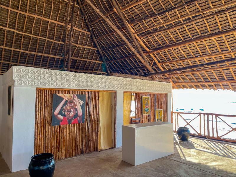 Offener Hotelbereich mit hölzernen Dach und Rezeptionstresen unter natürlichem Licht.