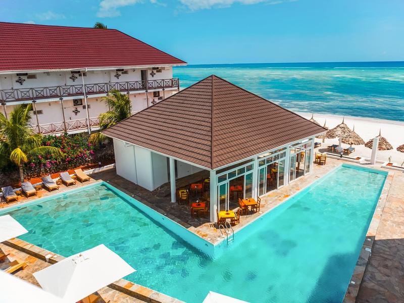 Moderner Pool mit zentralem Pavillon und Strandblick in einem Resort.
