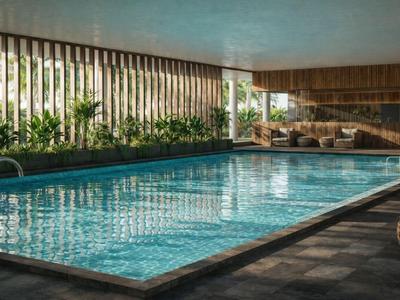 Innenpool mit klaren Wasser, umgeben von Holzvertäfelung und grünen Pflanzen, Lounge-Bereich im Hintergrund.