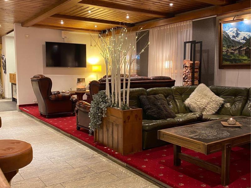 Przytulny hotelowy salon z skórzanymi meblami, wykładziną i drewnianym sufitem.