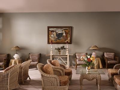 Ein Wohnzimmer mit Korbsesseln, Sofas und Tischen in warmen Beige- und Brauntönen.